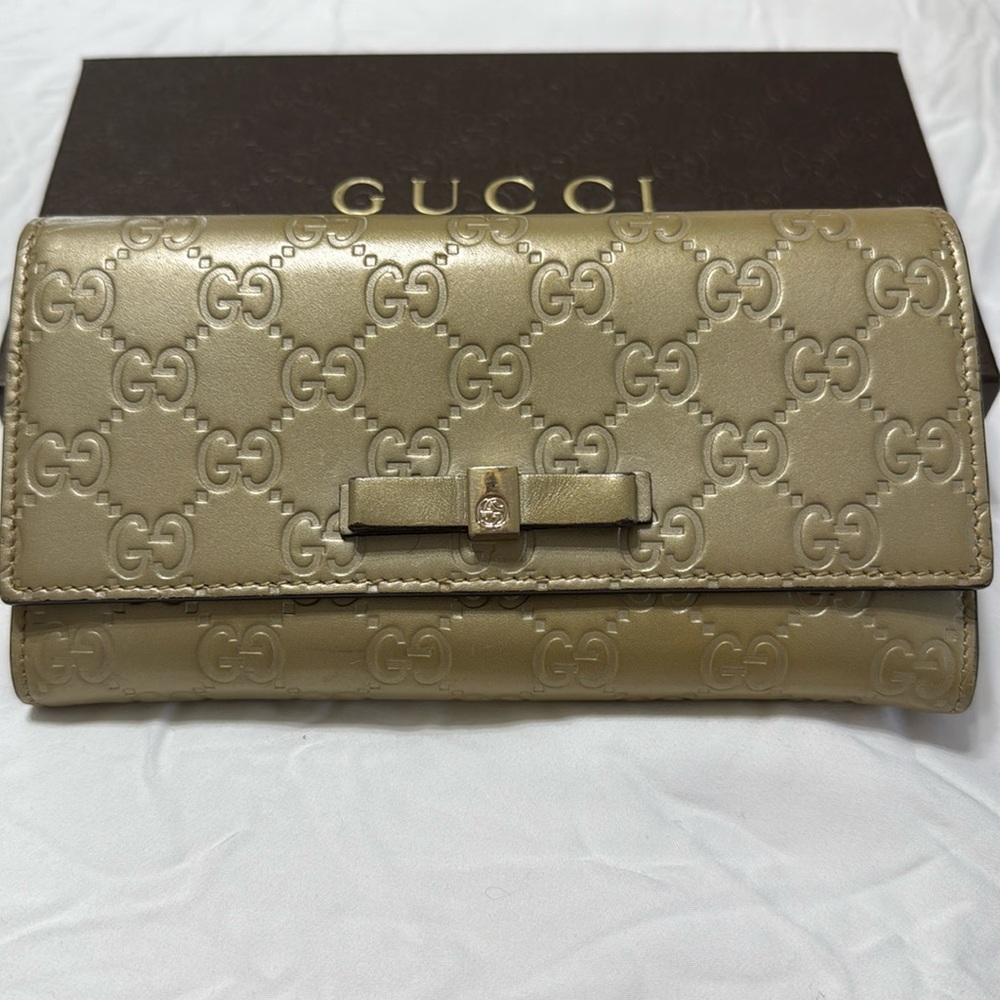 Gucci Gold Wallet with Interlocking G Pattern and Metallic Closure